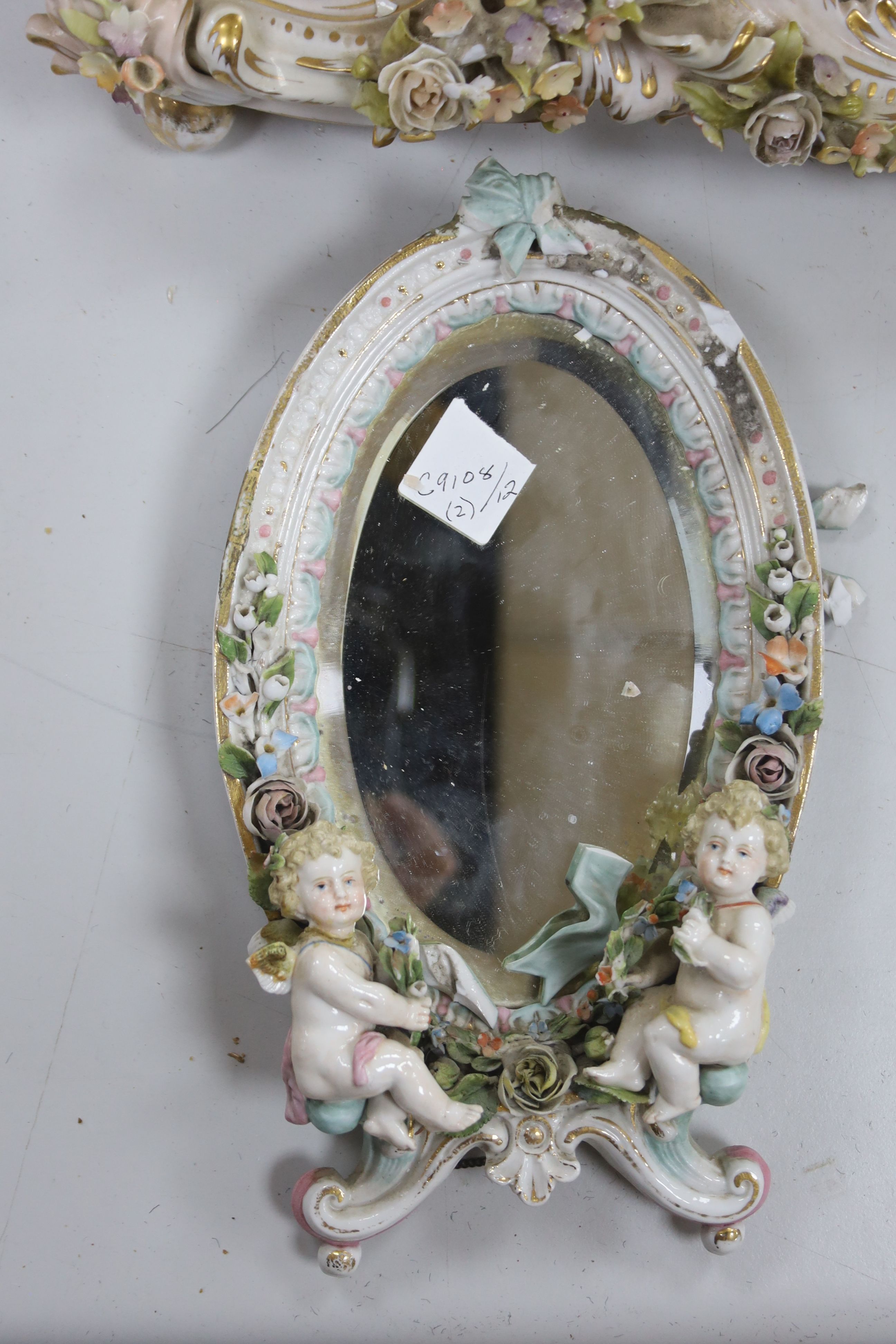 A large 19th century German porcelain easel mirror, height 60cm, and a smaller oval porcelain mirror